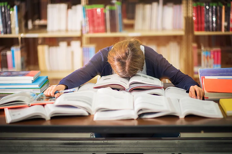 Student overwhelmed with books - New Year's study resolutions
